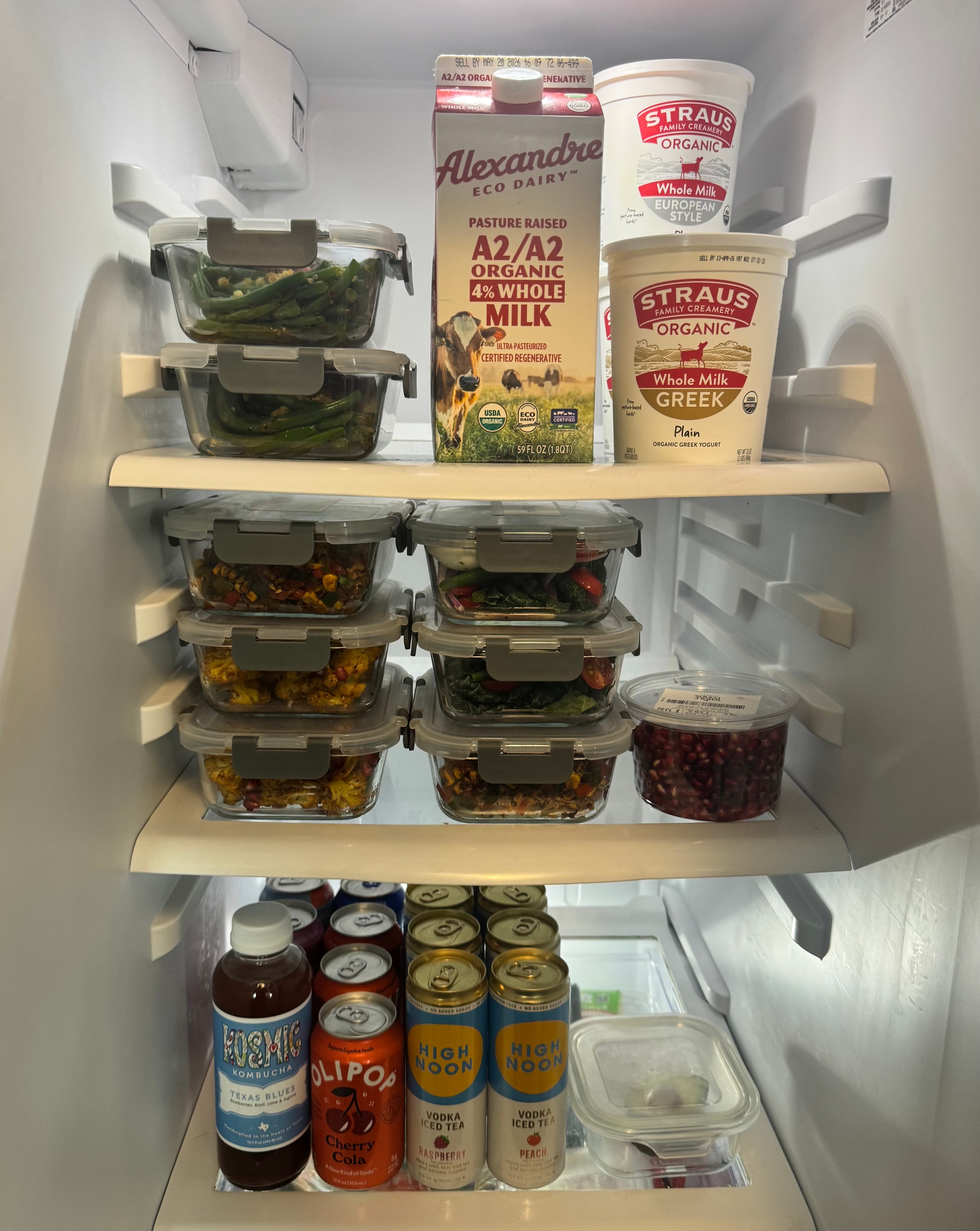 A client's fridge fully stocked with a week of fresh, labeled meal prep containers from Eats by ATX
